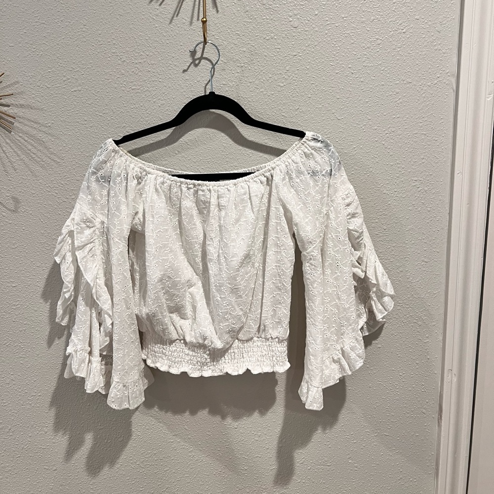 White cropped blouse, with fringe sleeves that are cut out
